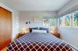 This cozy bedroom features a stylish bed with a geometric patterned comforter, creating a focal point in the room.