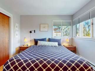 This cozy bedroom features a stylish bed with a geometric patterned comforter, creating a focal point in the room.