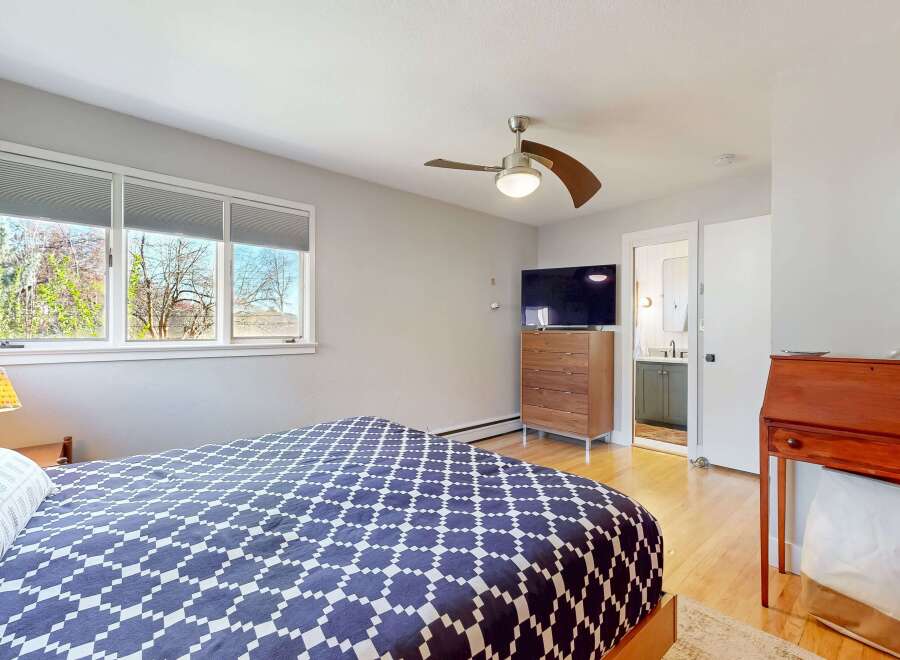 This inviting bedroom features a stylish bed with a unique patterned comforter, creating a cozy and modern atmosphere.