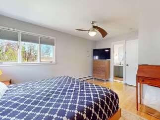 This inviting bedroom features a stylish bed with a unique patterned comforter, creating a cozy and modern atmosphere.