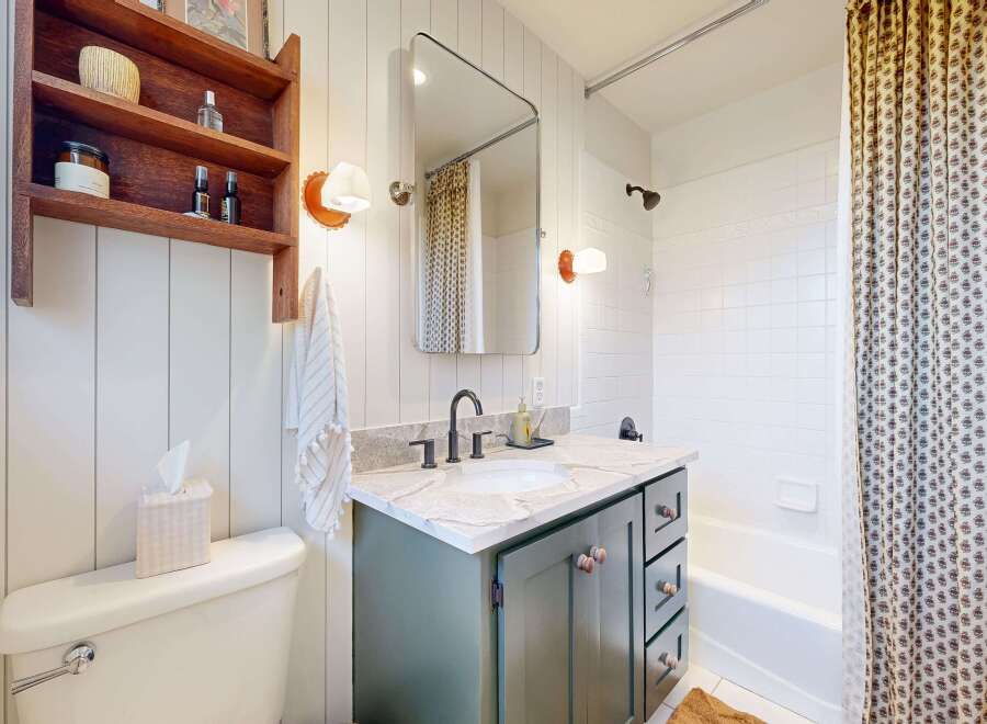 Step into this charming bathroom, featuring a stylish vanity with ample storage and a sleek countertop.