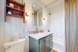 Step into this charming bathroom, featuring a stylish vanity with ample storage and a sleek countertop.
