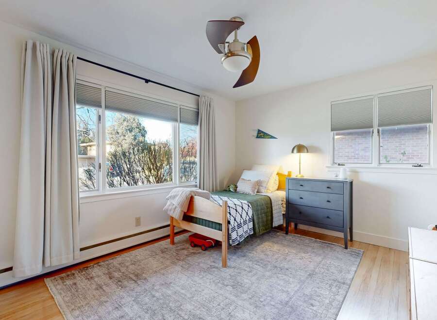 This charming bedroom offers a cozy retreat with its inviting design and ample natural light.