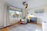 This charming bedroom offers a cozy retreat with its inviting design and ample natural light.