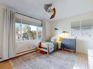 This charming bedroom offers a cozy retreat with its inviting design and ample natural light.
