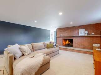 This cozy living room features a stunning brick fireplace, perfect for creating a warm and inviting atmosphere.