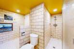 Step into a unique bathroom design featuring a vibrant yellow ceiling and classic tilework.