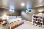 This cozy bedroom offers a serene retreat with its neutral color palette and ample natural light.