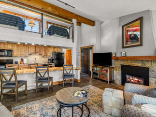 This cozy living space features a stunning stone fireplace, perfect for those chilly evenings.