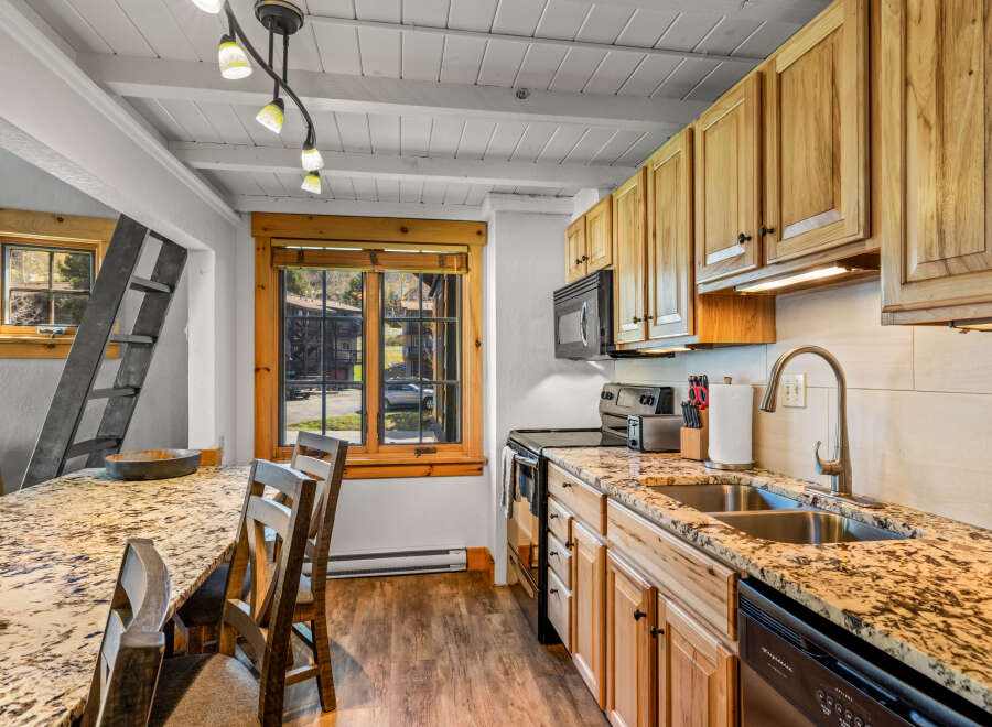 This charming kitchen boasts a rustic aesthetic with its wooden cabinetry and granite countertops.