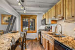 This charming kitchen boasts a rustic aesthetic with its wooden cabinetry and granite countertops.