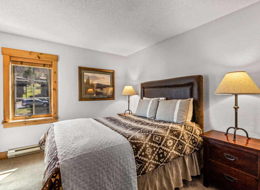 This cozy bedroom features a comfortable bed with a patterned comforter and a stylish headboard.