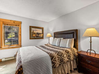 This cozy bedroom features a comfortable bed with a patterned comforter and a stylish headboard.