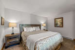 This cozy bedroom features a rustic wooden headboard and nightstands, creating a warm and inviting atmosphere.