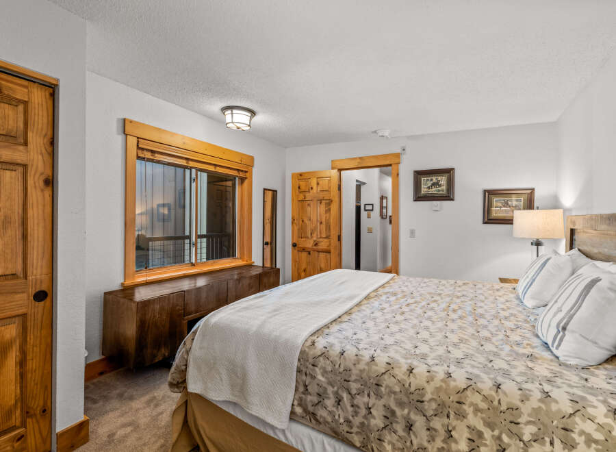 This inviting bedroom features a cozy ambiance with its warm wooden accents and neutral color palette.