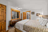 This inviting bedroom features a cozy ambiance with its warm wooden accents and neutral color palette.