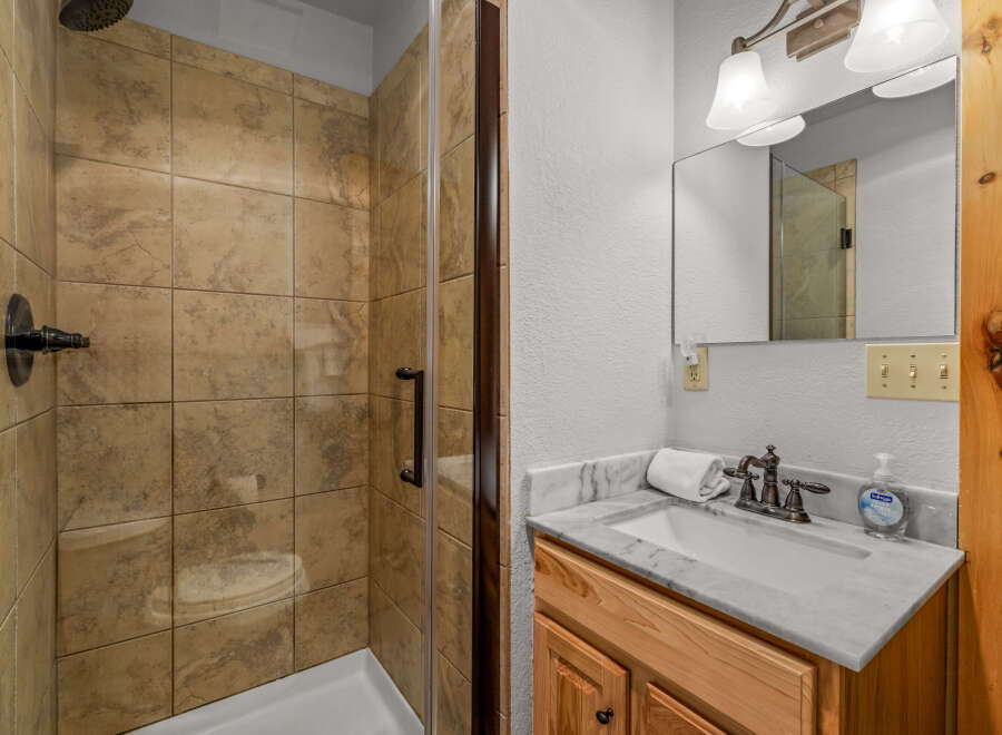 Step into this beautifully designed bathroom featuring a modern shower with glass doors and elegant tile work.