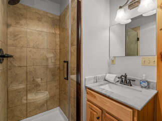 Step into this beautifully designed bathroom featuring a modern shower with glass doors and elegant tile work.