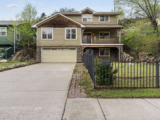 This stunning two-story home boasts a charming exterior with a stone facade and a welcoming porch.