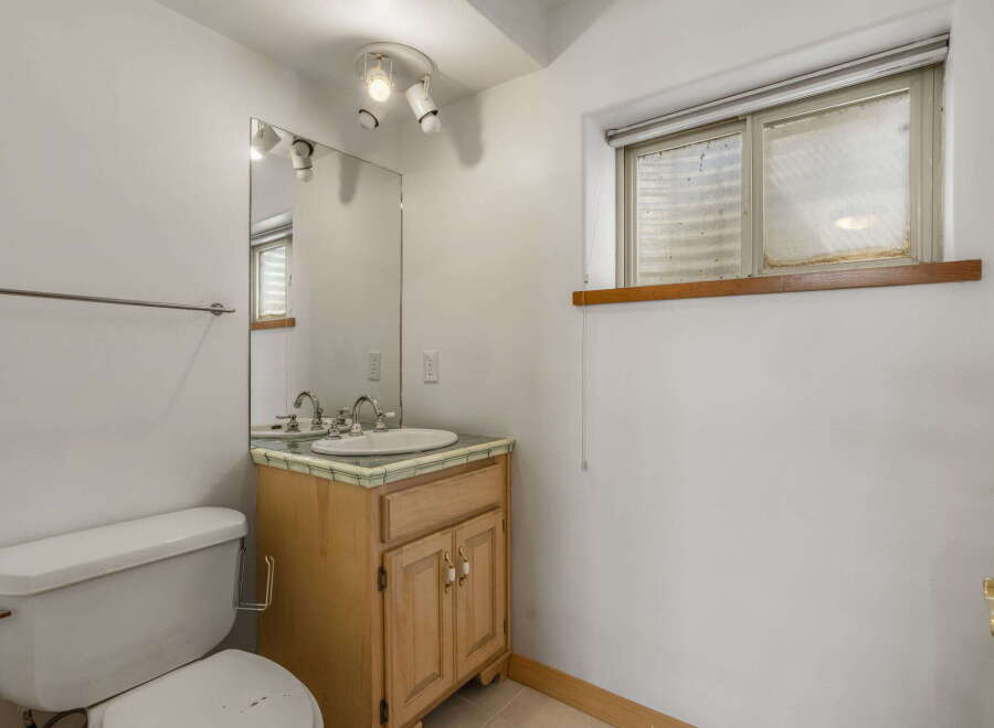 Discover the charm of this well-maintained bathroom, featuring a classic vanity with ample storage and a stylish sink.