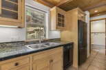This charming kitchen boasts a rustic aesthetic with its wooden cabinetry and exposed beams.