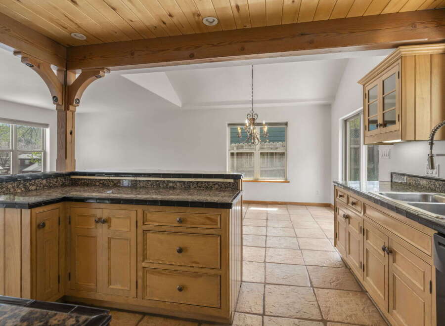 Step into this inviting kitchen, featuring warm wooden cabinetry and a stunning granite countertop.