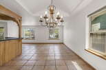 Step into this inviting space, featuring a stunning chandelier and elegant tile flooring.
