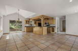 This stunning kitchen boasts a unique design with a central island and wooden beams, creating a warm and inviting atmosphere.