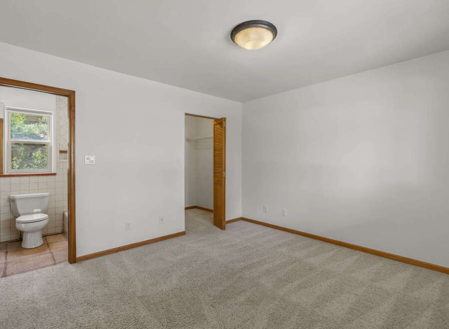 Step into this inviting bedroom, featuring a neutral color palette and plush carpeting.