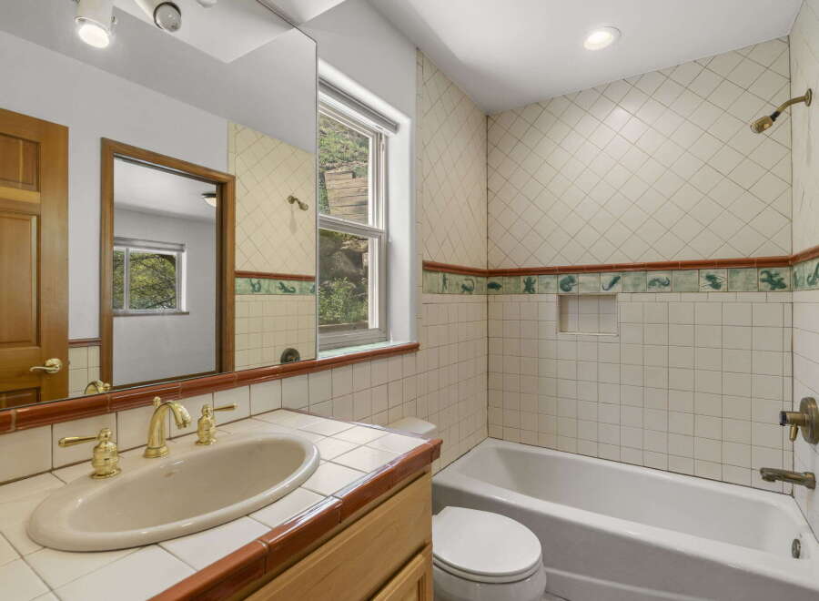 Step into this charming bathroom, featuring a classic design with tiled walls and a cozy atmosphere.