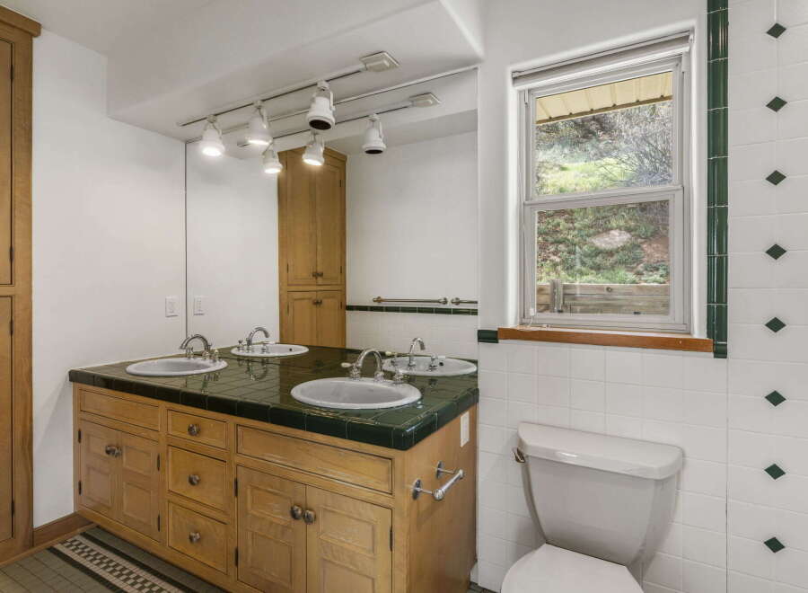 This charming bathroom features a double vanity with a wooden cabinet, offering ample storage space.