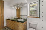 This charming bathroom features a double vanity with a wooden cabinet, offering ample storage space.