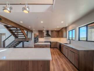 This stunning kitchen boasts a modern design with sleek wooden cabinetry and a spacious island, perfect for culinary enthusiasts.