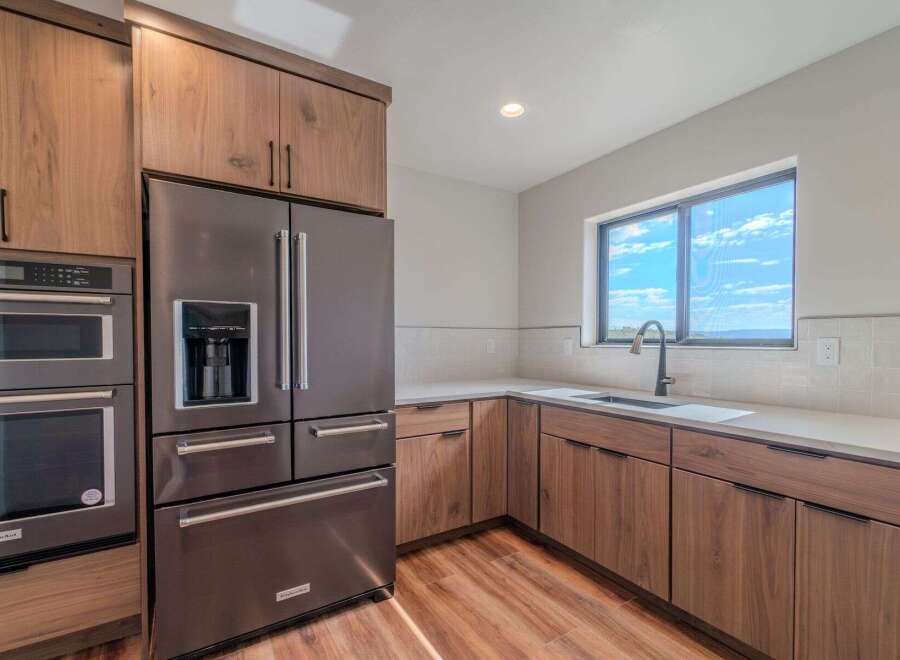This stunning kitchen boasts modern appliances and elegant wood cabinetry, creating a warm and inviting atmosphere.