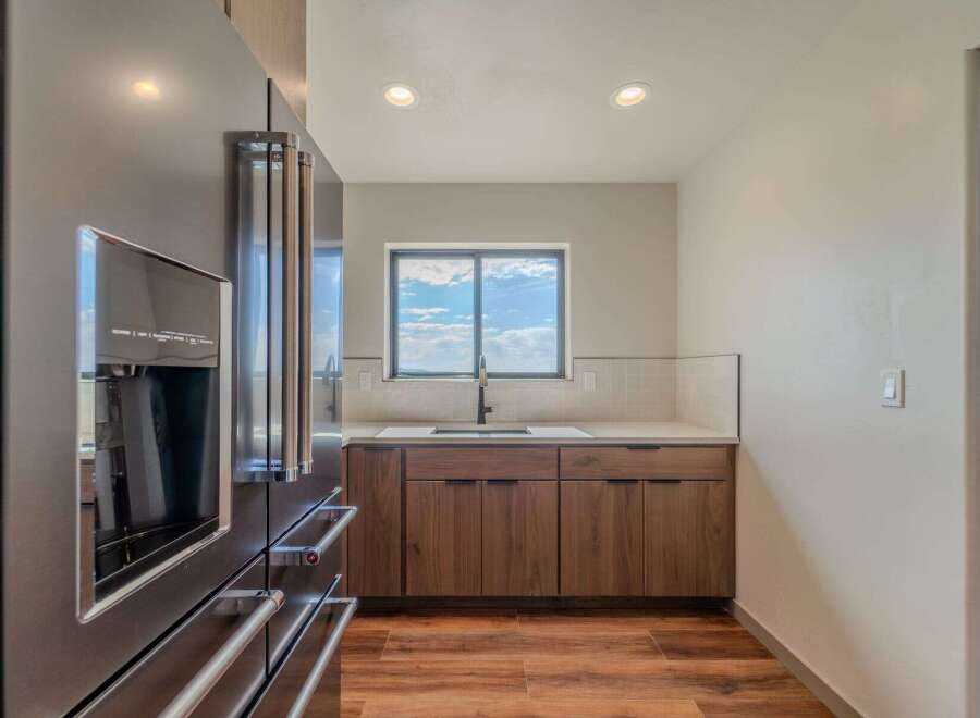 This modern kitchen boasts sleek stainless steel appliances and custom wood cabinetry, creating a stylish and functional space.
