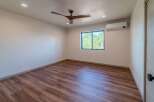 Step into this inviting bedroom featuring stunning wood-look flooring and a modern ceiling fan.