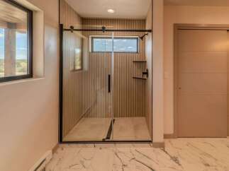 Step into luxury with this stunning bathroom featuring a sleek glass shower enclosure.