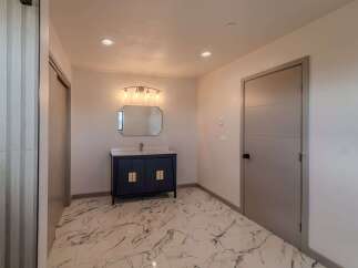 Step into luxury with this stunning bathroom featuring a modern vanity and elegant lighting fixtures.