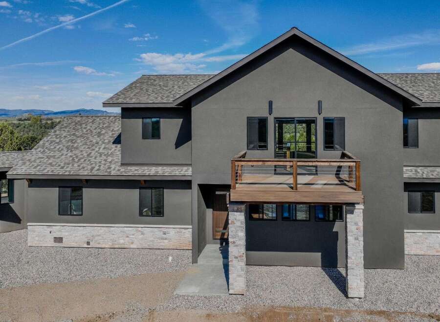 This stunning modern home boasts a sleek, contemporary design with a striking dark gray exterior.