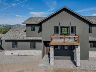 This stunning modern home boasts a sleek, contemporary design with a striking dark gray exterior.