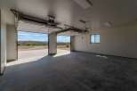 This spacious garage offers ample room for vehicles and storage, featuring a sleek, modern design.