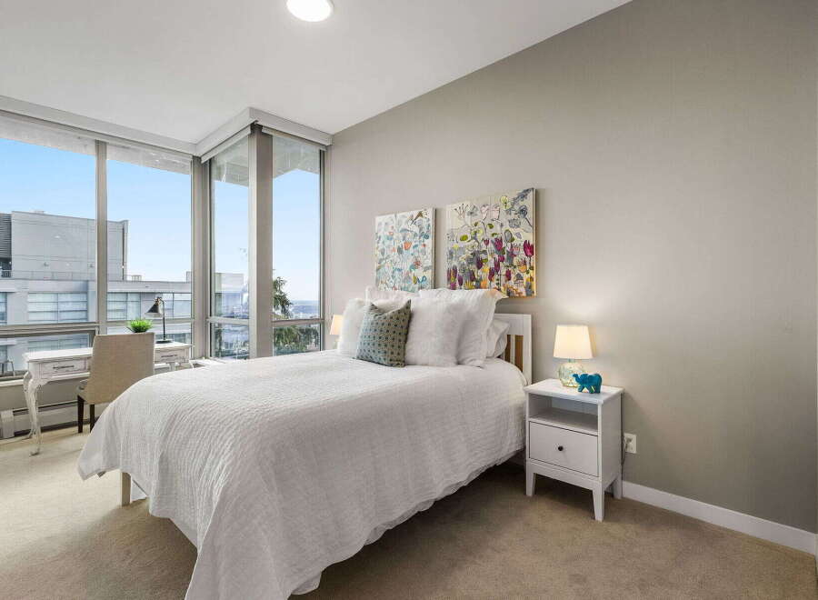 Experience luxury living in this stunning bedroom with breathtaking city views.