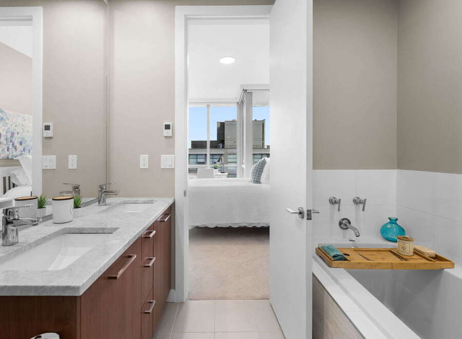 Step into luxury with this stunning bathroom featuring a double vanity with a marble countertop and sleek fixtures.