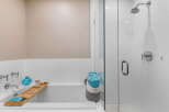 Step into luxury with this stunning bathroom featuring a sleek glass shower and a relaxing bathtub.