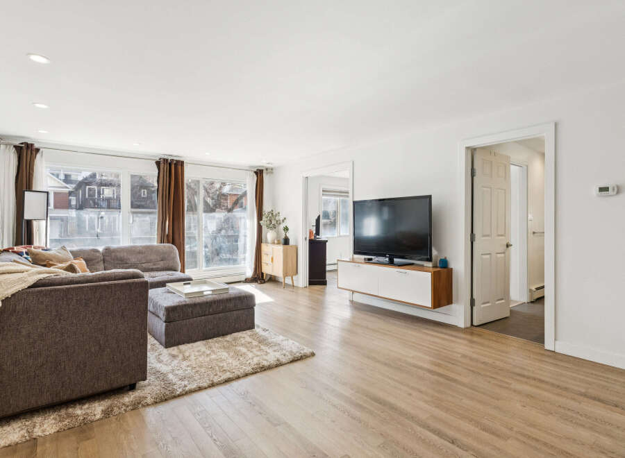 Step into this inviting living space, featuring a modern aesthetic with its sleek TV and floating cabinet.
