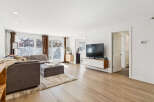 Step into this inviting living space, featuring a modern aesthetic with its sleek TV and floating cabinet.