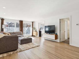 Step into this inviting living space, featuring a modern aesthetic with its sleek TV and floating cabinet.