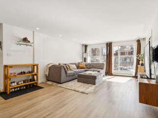 Step into this inviting living space, featuring a modern sectional sofa and a cozy ottoman, perfect for relaxation.