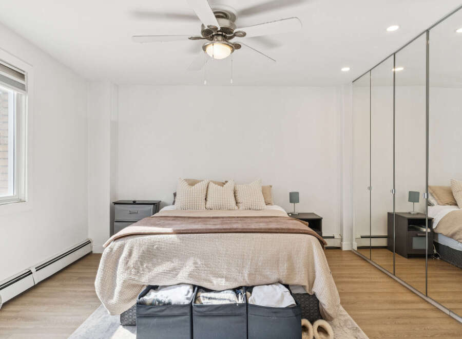 This inviting bedroom boasts a serene ambiance with its neutral color palette and ample natural light.