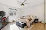 This inviting bedroom boasts a cozy atmosphere with its neutral color palette and ample natural light.